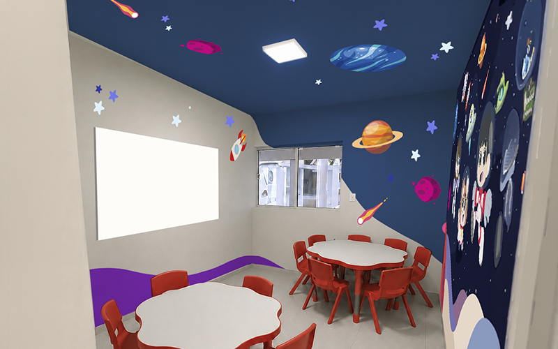 Sala Espaço da Knowa com decoração de planetas, estrelas e mesas infantis vermelhas